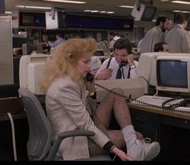 映画「ワーキング・ガール」の一コマ：80年代のリーボックを通勤シューズに履くスタイル (working-girl_melanie-griffith_reebok_sneakers_office)